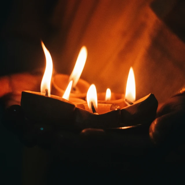 the flames of candles from a cake are glowing orange