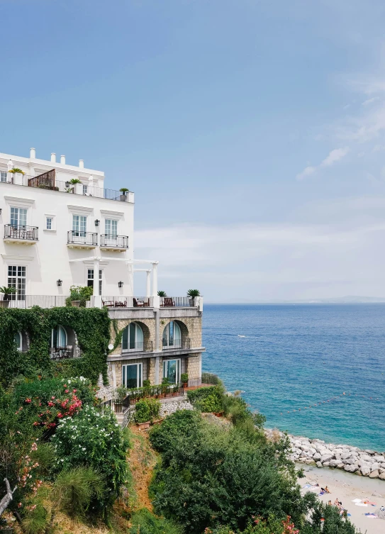 an elegant home overlooks the ocean on a hill