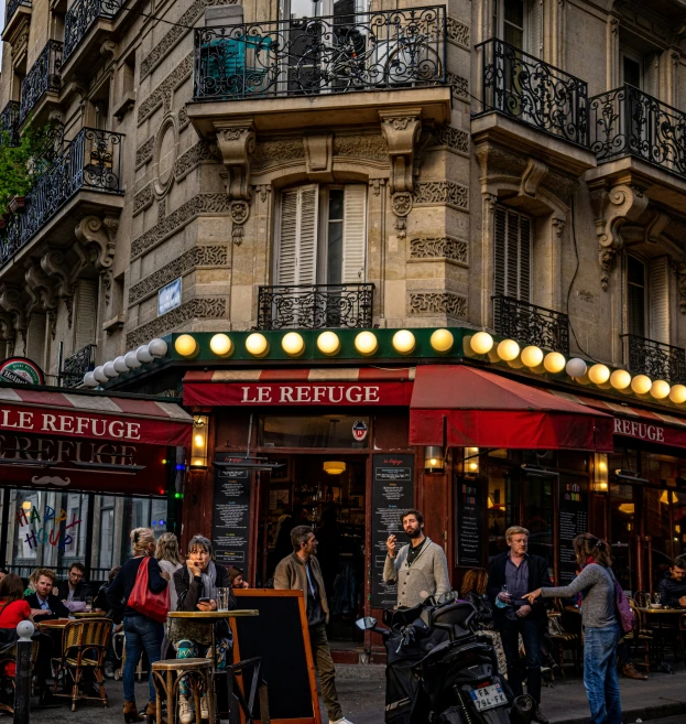 some people standing outside an empty restaurant by the sidewalk