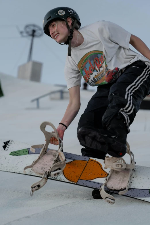 a young man is standing on his snowboard with one foot on the board