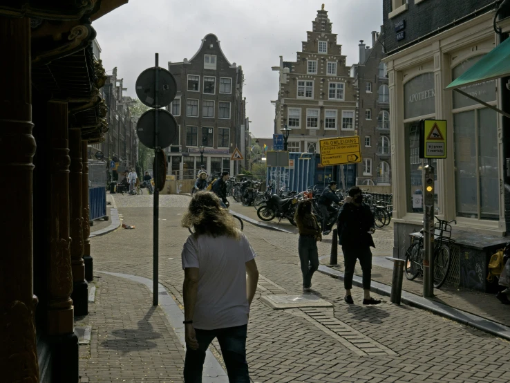 a bunch of people standing outside and walking on a street