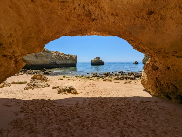 there is a beach under a stone archway