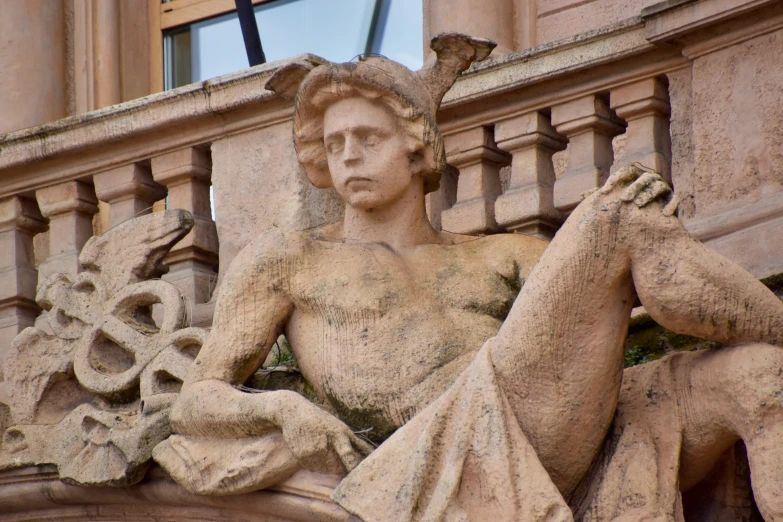 close up of statue of a male figure with a clock on top