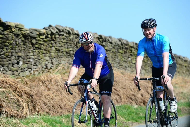 a man and a woman riding bikes along a road