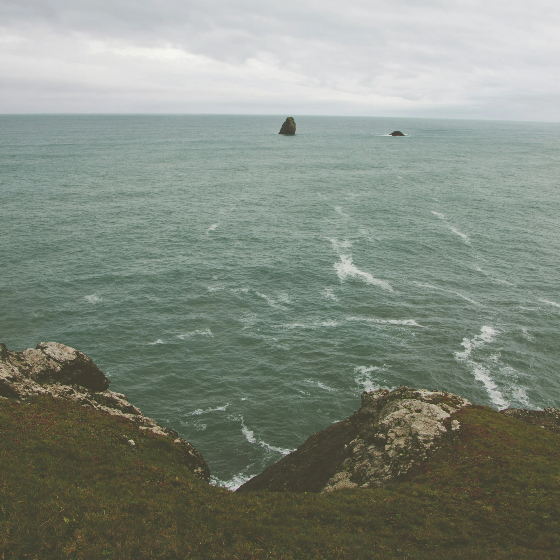 a lone boat in the open water near some rock formations