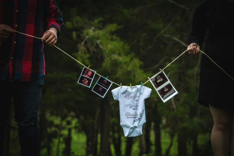 two people walking down a path holding some baby ones clothes