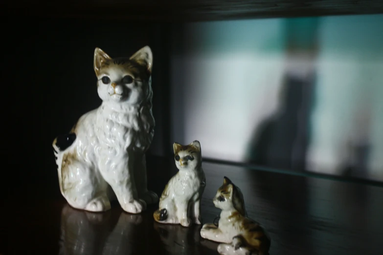 three cat figurines are sitting on a table