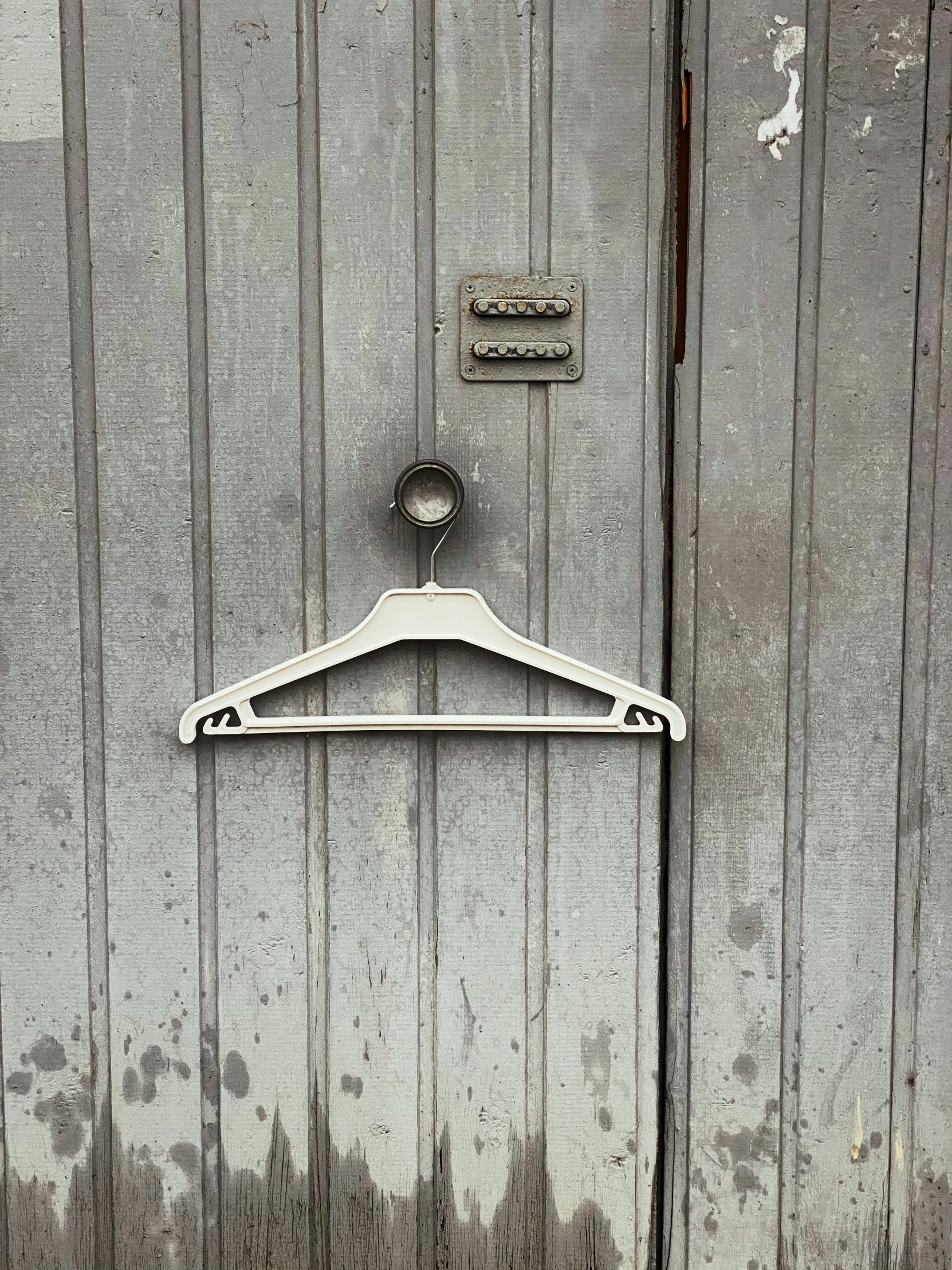 an open hanger sits on the wall with an empty bottle