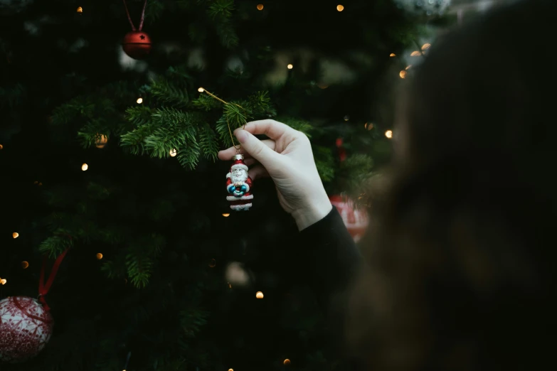 a person is holding a christmas ornament in their hand