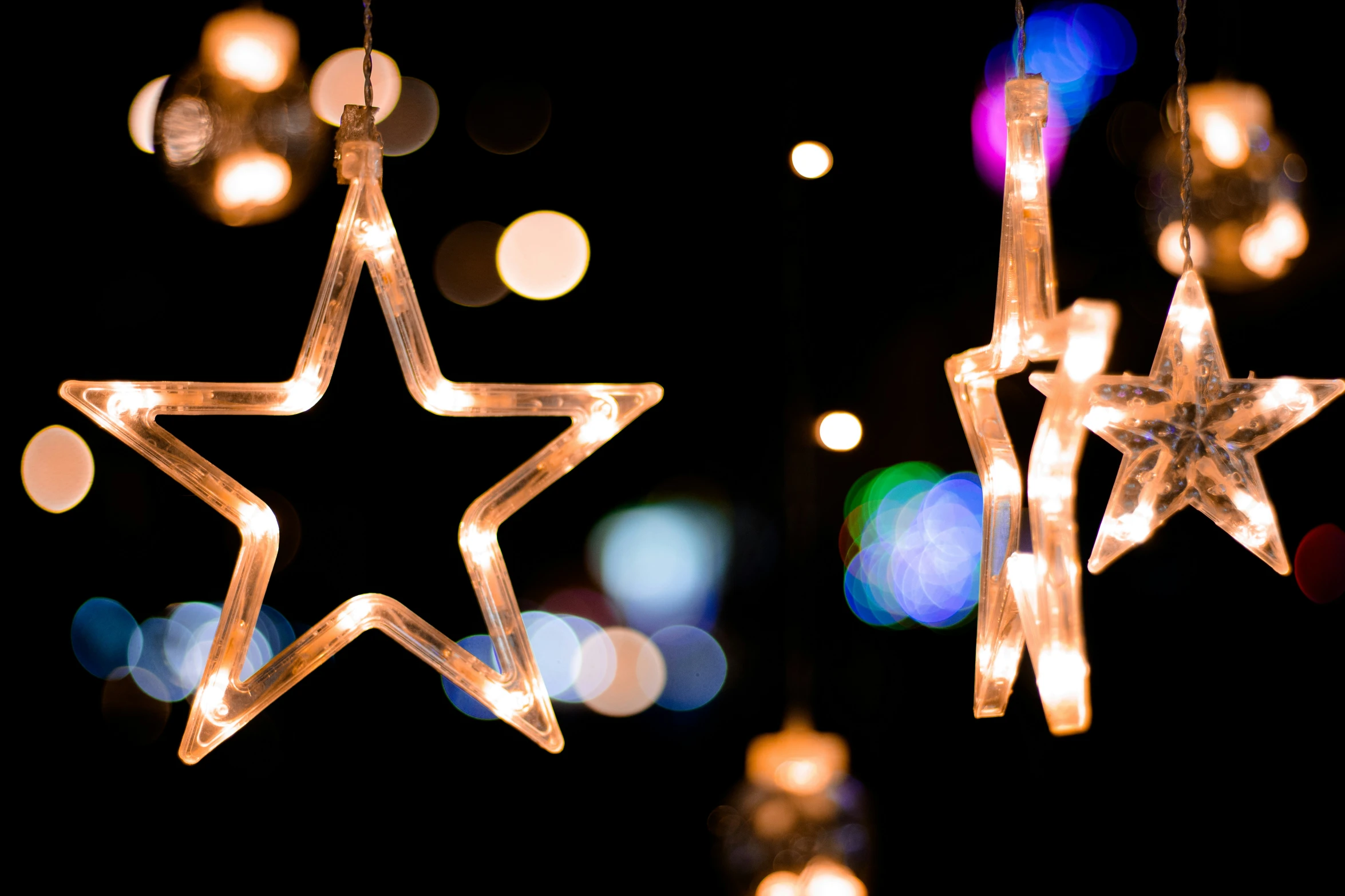 lighted stars hanging in the dark against a black background