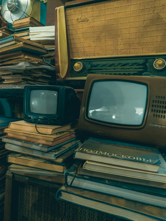 a stack of old televisions with old fashioned books on them
