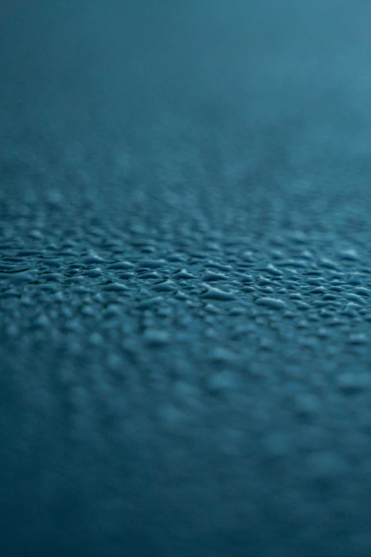 water drops on blue background with water ripples in the foreground