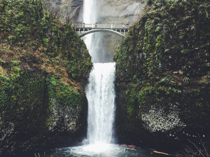 a big tall waterfall next to a road