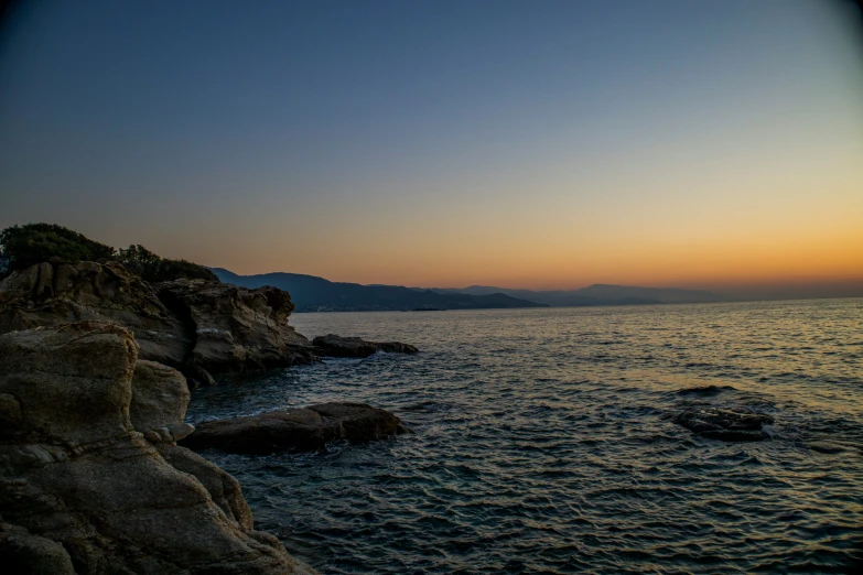 a very long cliff out side on the ocean at sunset