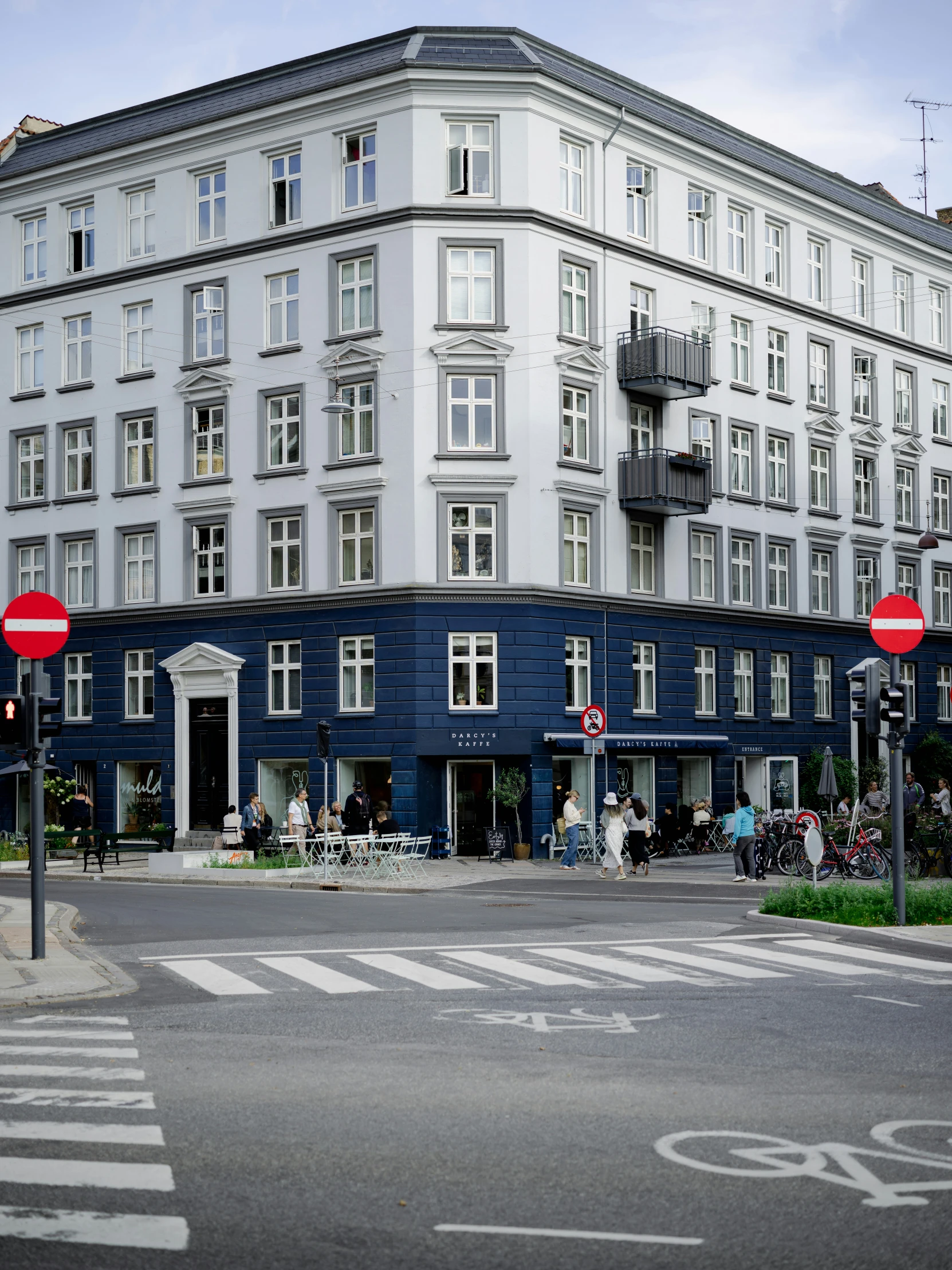 a blue building sitting on the corner with a street corner