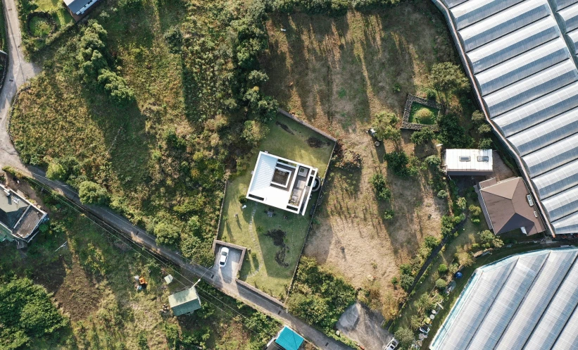 an aerial po of a garden and a home in the distance