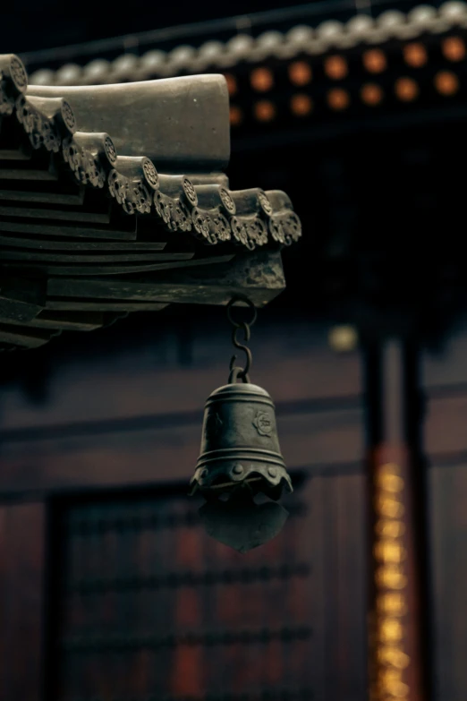 a small bell with decorative carvings hanging from a building