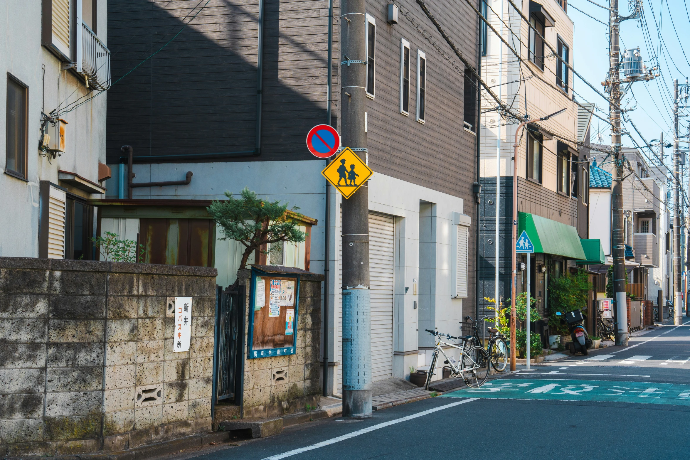 an empty street with several houses, and an orange sign above the street