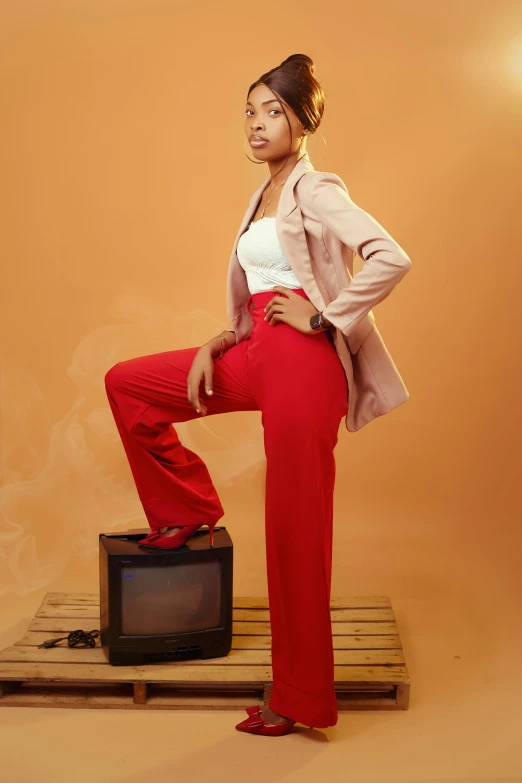 a woman is standing on a box while wearing red pants