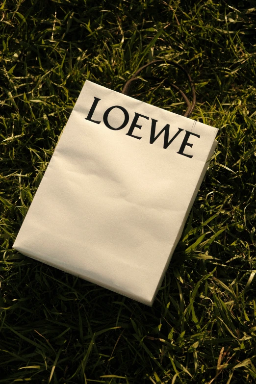 a white piece of paper with the word loewe laid on the grass