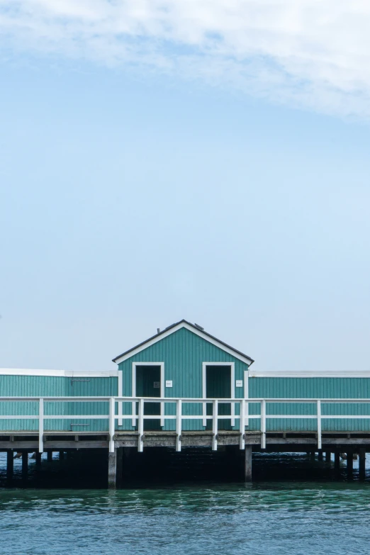 a blue building sitting in the middle of water