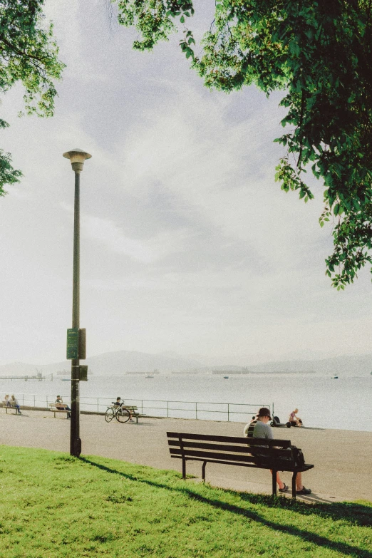 a man sitting on a bench near the beach