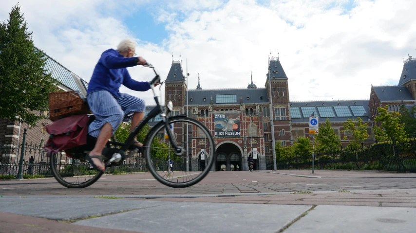 a woman riding a bicycle with baskets on her back