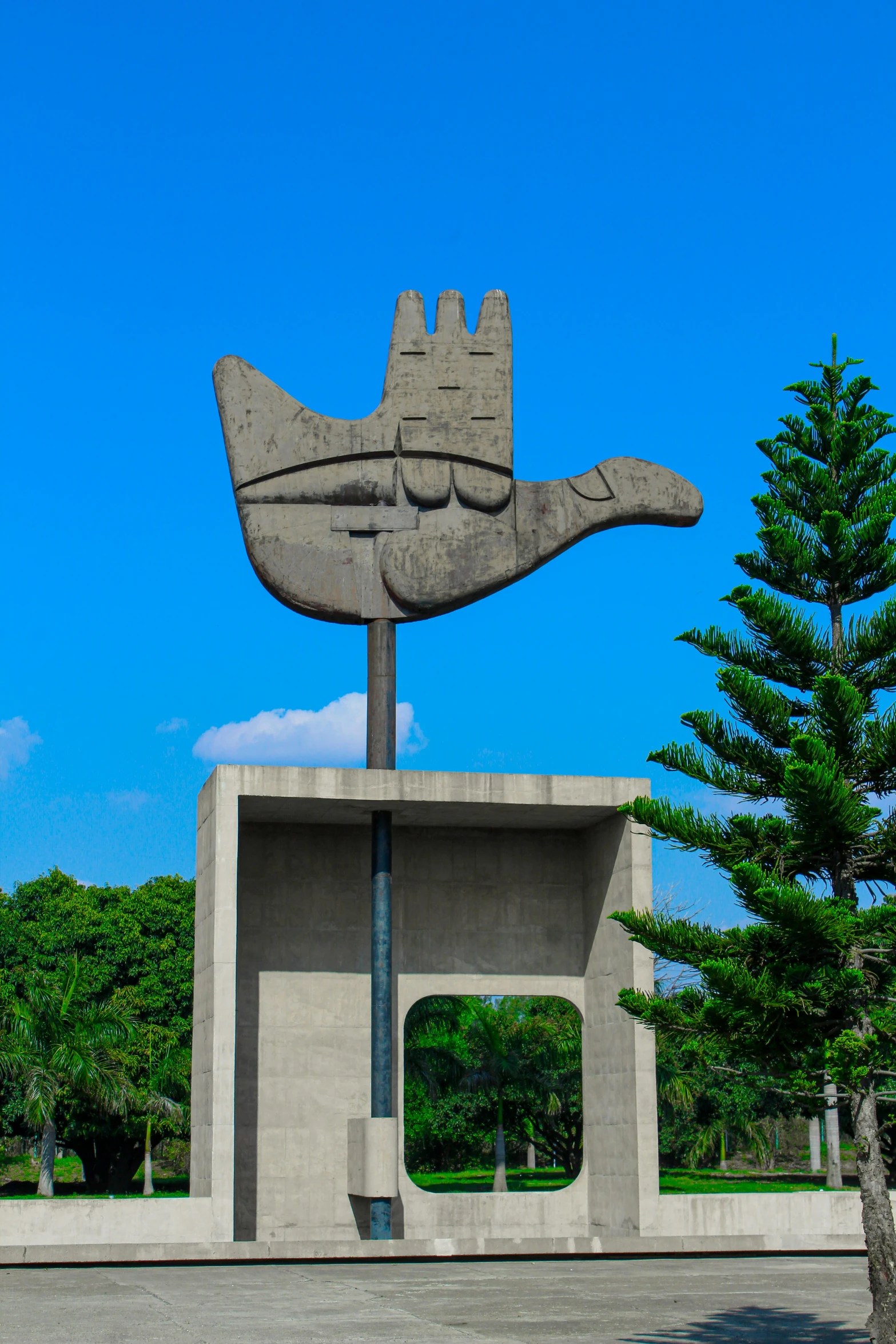 the large, concrete sculpture has an interesting hand and symbol