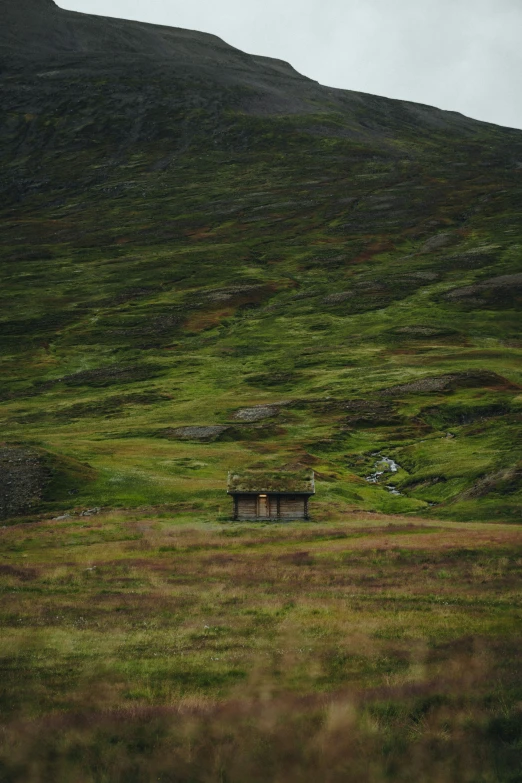 a couple of benches sitting in front of a grassy hill