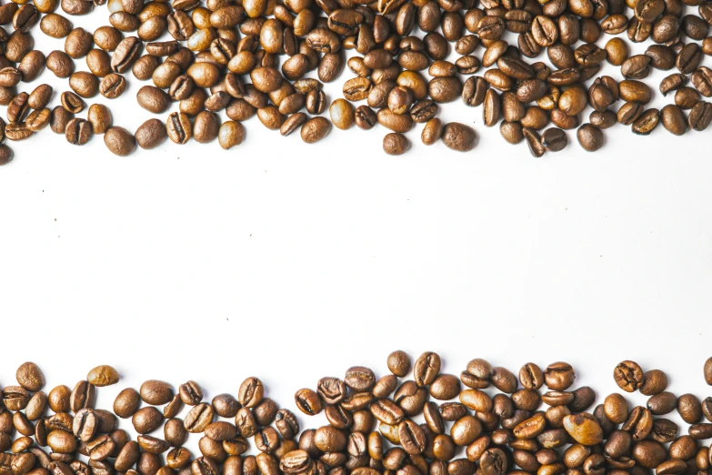 an overhead view of coffee beans on a white background