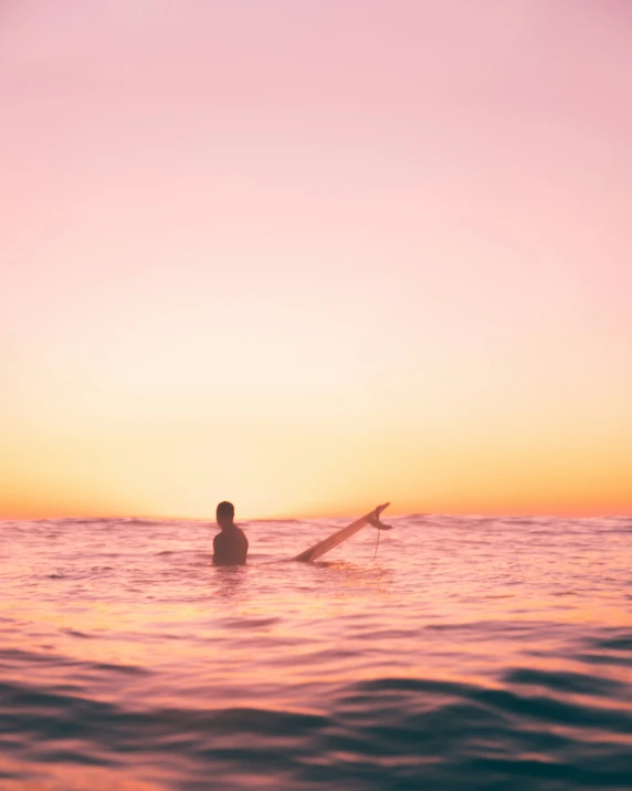 a person floating on top of a surfboard in the ocean