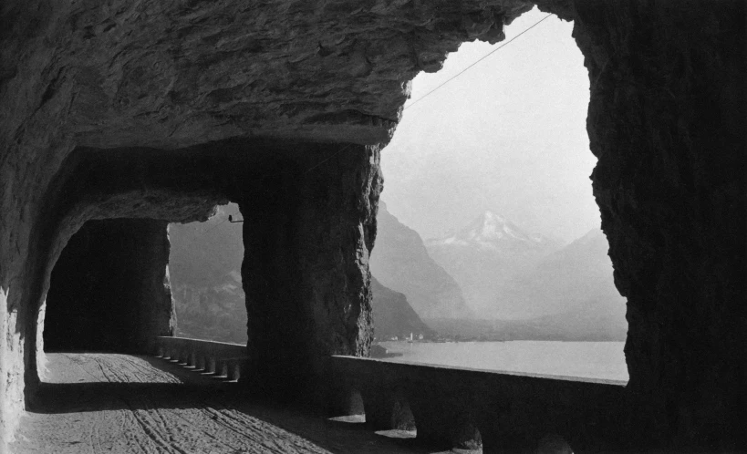 a road between two large cliffs with mountains in the distance