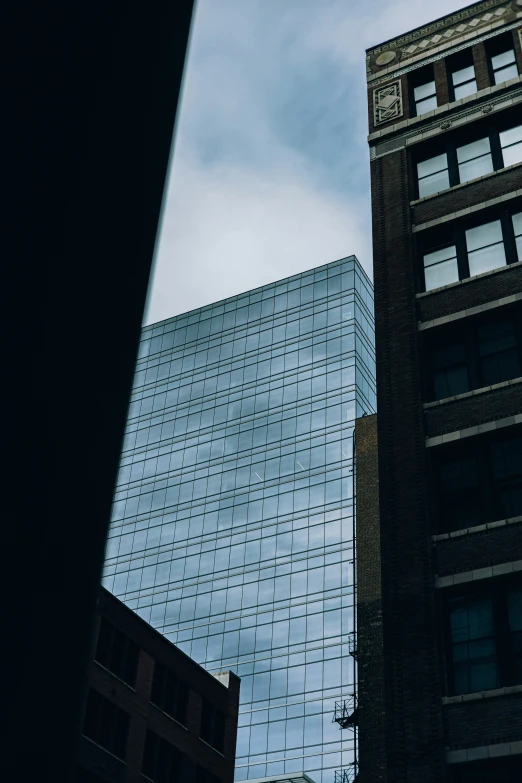 a tall building and other buildings are silhouetted against the sky