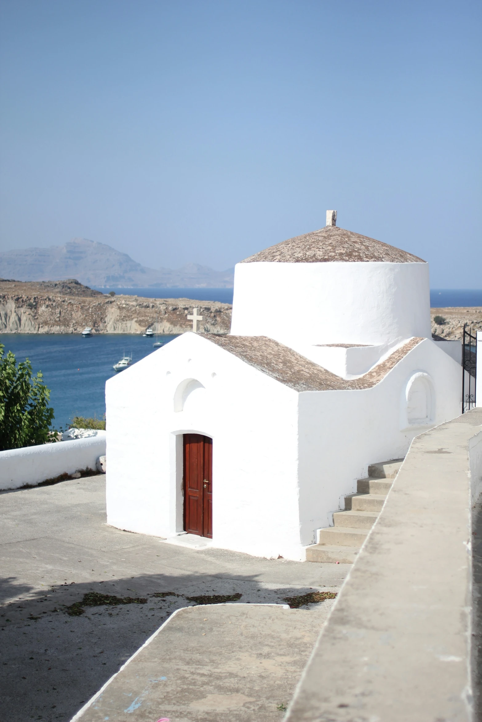 an old church stands on the edge of a cliff by a body of water