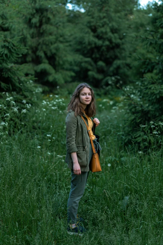 a woman standing in a field of tall green grass