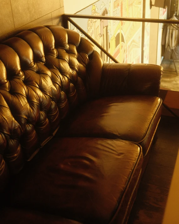 a leather couch sitting in front of a window