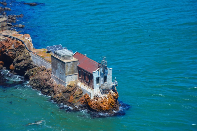 an old building on the edge of the sea near the shore