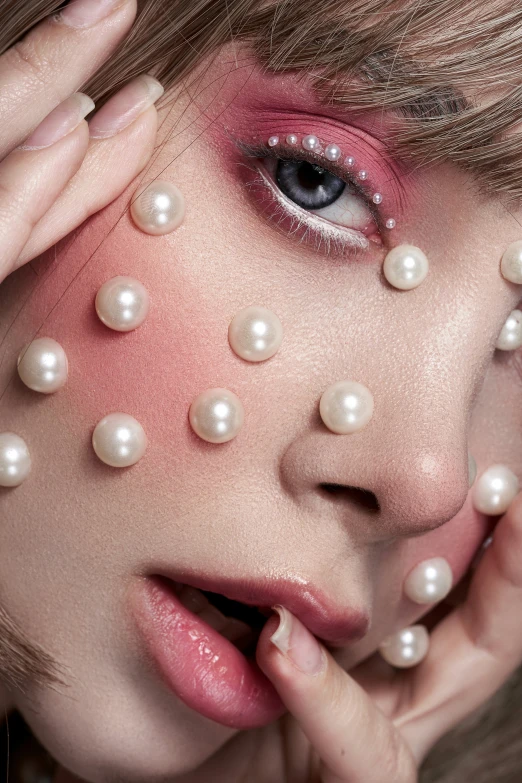 a close - up s of the girl has pearls all over her face