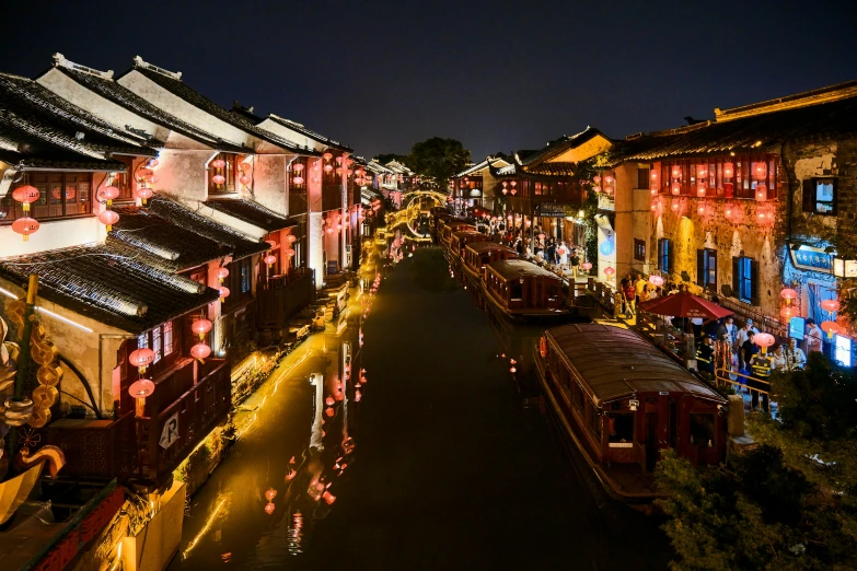 the walkway of an asian city lit up in night