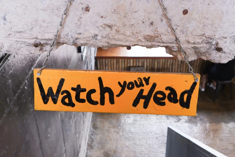 the sign that is on the wall says, watch you head