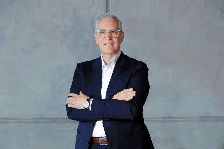 a man wearing glasses and a suit posing for the camera