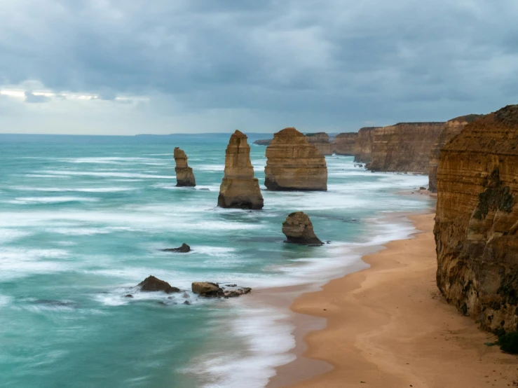 view of a sandy shore with waves crashing on it