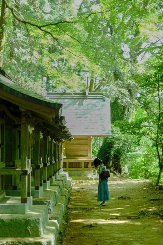 the woman is walking through the park with an umbrella