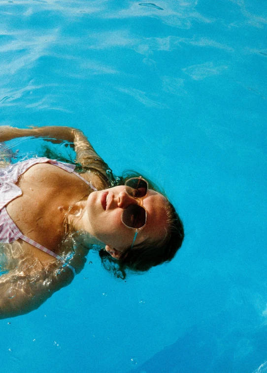 a woman in a bikini swimming on a pool board