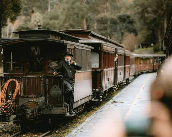 a man standing on top of a train car next to other trains