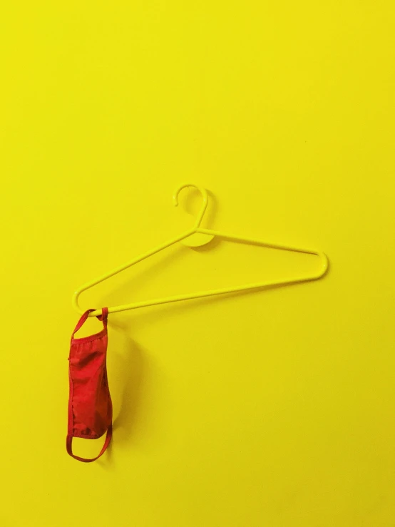 a red umbrella sitting on top of a white hanger