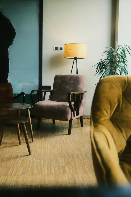 an apartment with two chairs next to a table and two lamps