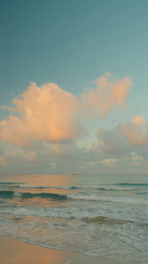 a person standing on the beach with their surfboard in hand