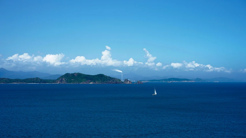 sail boat on the open ocean under cloudy skies