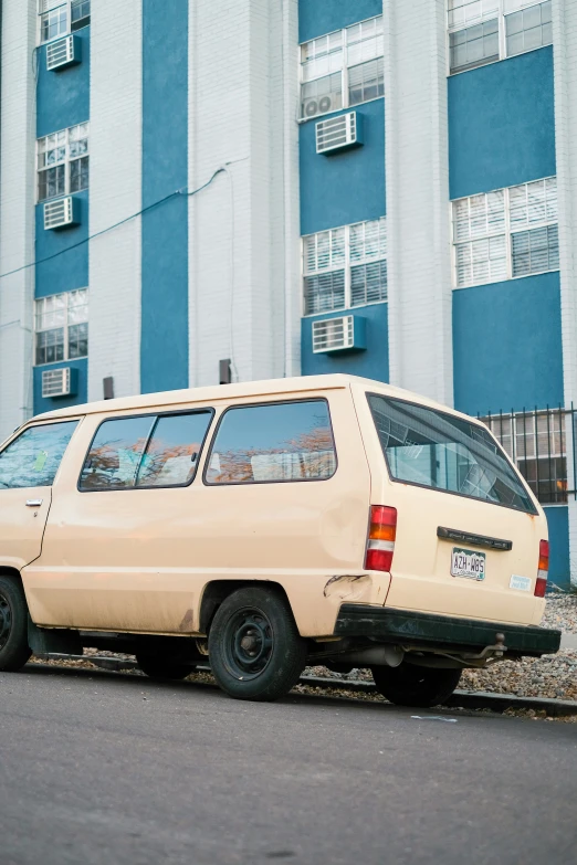 the car is parked near the large building